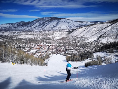 person in red jacket and blue pants riding ski blades on snow covered ground during daytime